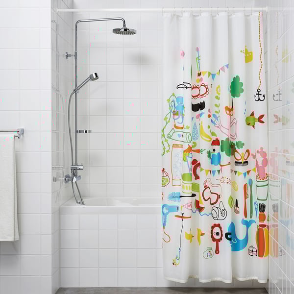 A bathroom with a white tiled wall, a shower with a extendable curtain rod and a vibrant shower curtain featuring various cartoonish items.