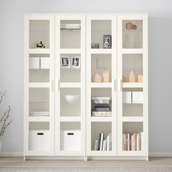 White BRIMNES glass-door display cabinet with adjustable shelves for books and decor.