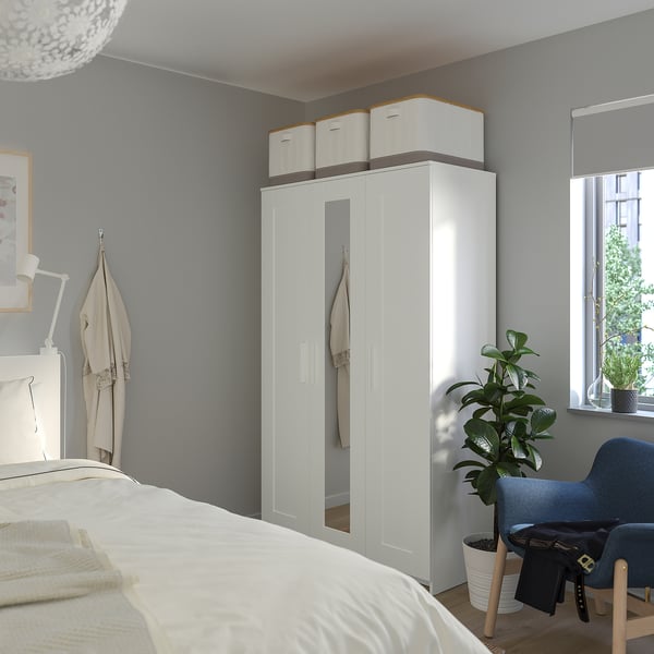 BRIMNES white wardrobe with mirrored doors, providing ample storage and enhancing room brightness.