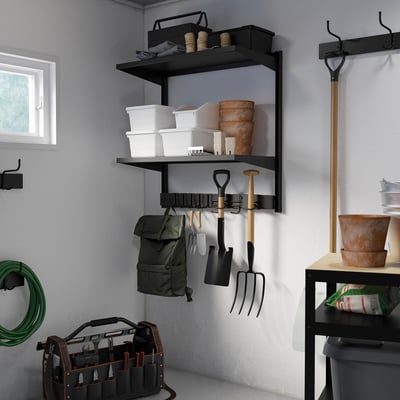 Black metal BROR garden storage with hooks and shelves, holding tools and equipment.