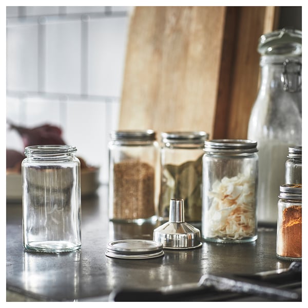 Glass spice jars with metal lids on counter, organised.
