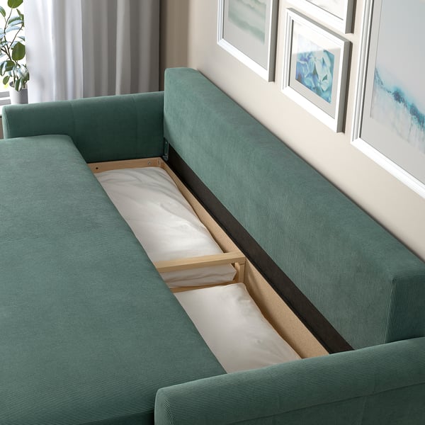 DÅNHULT teal sofa bed with storage, seen partially opened.