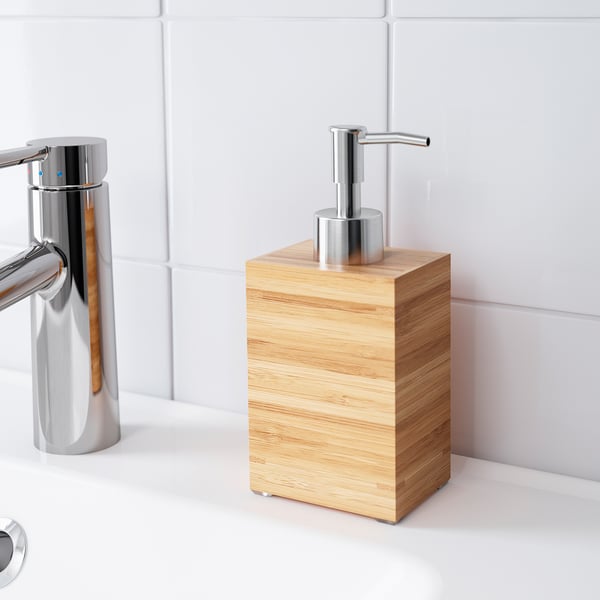 A modern bathroom with a chrome tap and a soap dispenser in a bamboo wood box.