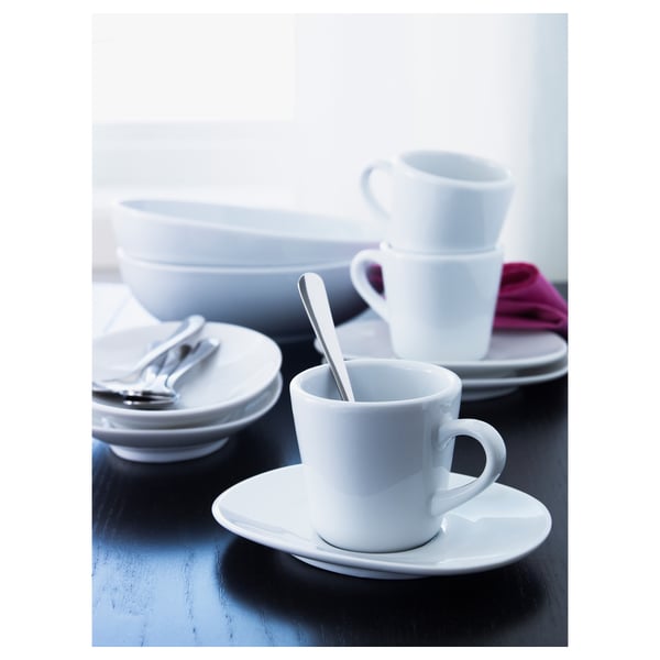 White ceramic coffee cups and bowls stacked neatly, with DRAGON stainless steel teaspoon.
