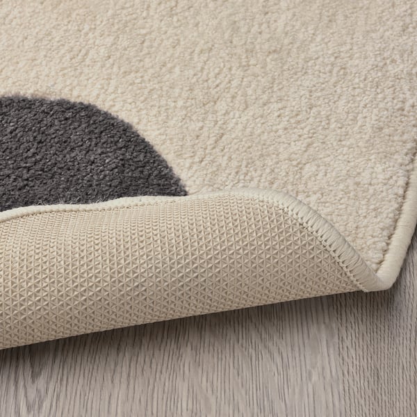 Beige rug corner with textured, non-slip rubber backing. Soft, durable material for childrens play.