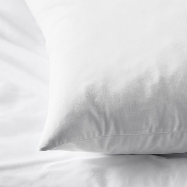Clean, crisp white bedding. Soft, high-quality cotton pillowcase, neatly arranged, inviting comfort.