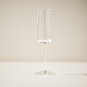 Single, elegant champagne flute with sleek, clear design, standing upright.