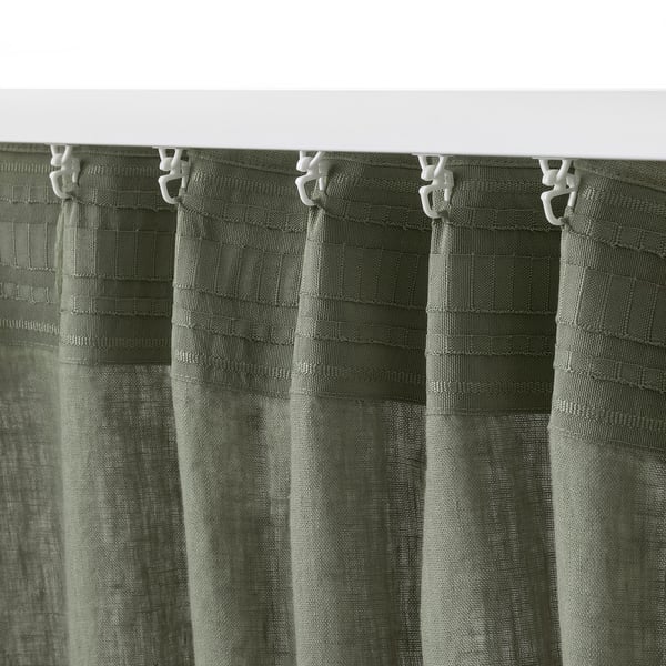 Green curtains with white hooks hang neatly, using rod pocket for easy hanging, allowing light filtering and privacy.