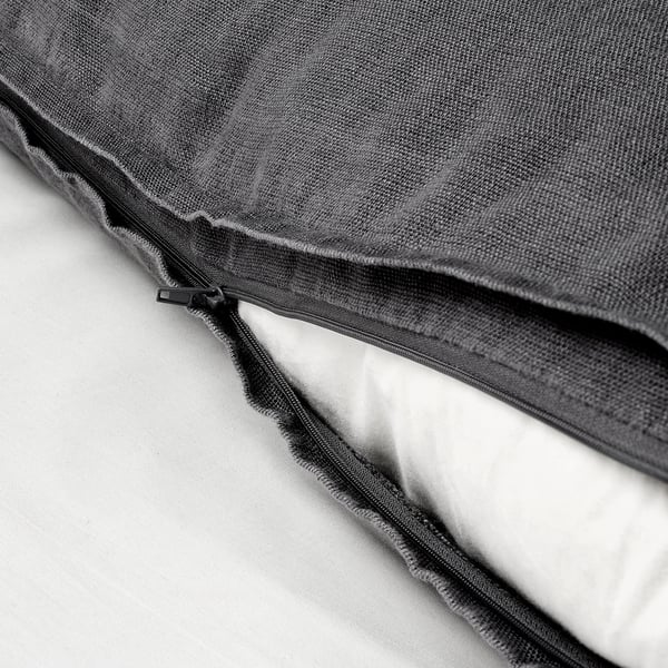 Close-up of cushion covers hidden zip on dark grey, textured linen fabric.