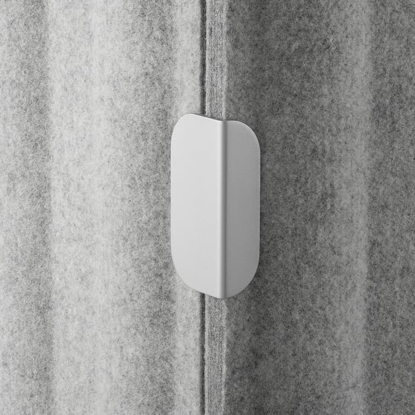 White oval object on textured grey wall, smooth finish.