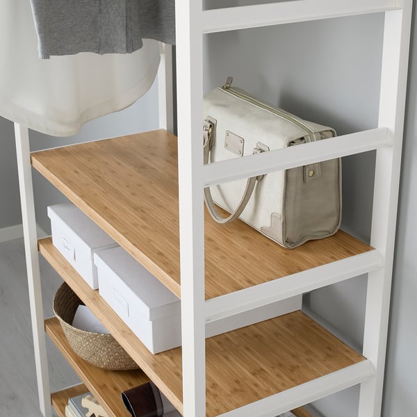 Wooden shelf unit with side pockets, holding boxes and a bag.