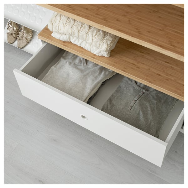 White drawer unit with open shelf, part of ELVARLI storage system, showing folded clothes inside drawer and on shelf.