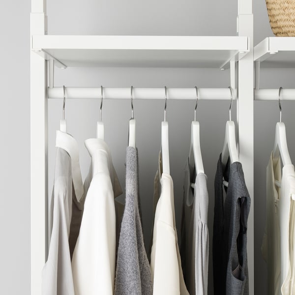 A modern closet featuring adjustable shelves and hanging rods, showcasing organised clothes in neutral tones.