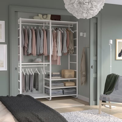 ELVARLI white wardrobe, open shelves with pastel clothes, fits neatly in room.