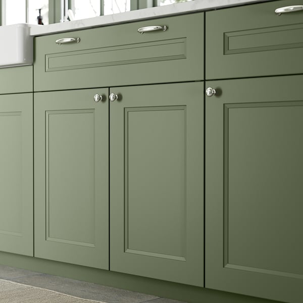 Green ENERYDA cabinets with silver handles, tall, sleek, blend well with light countertop.