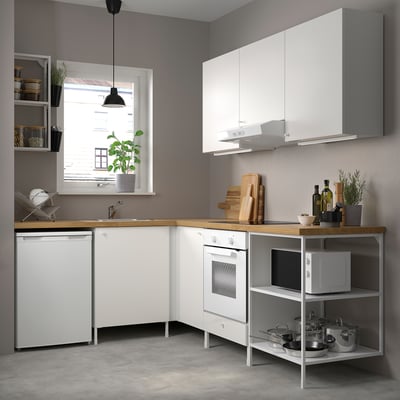 Modern white kitchen: ENHET series. Counters, microwave, stove, sink, and potted plants. Grey walls, concrete floor.