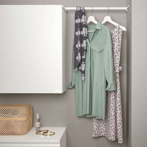 Closet rail between cabinets hanging clothes; includes extendable rail and hangers.