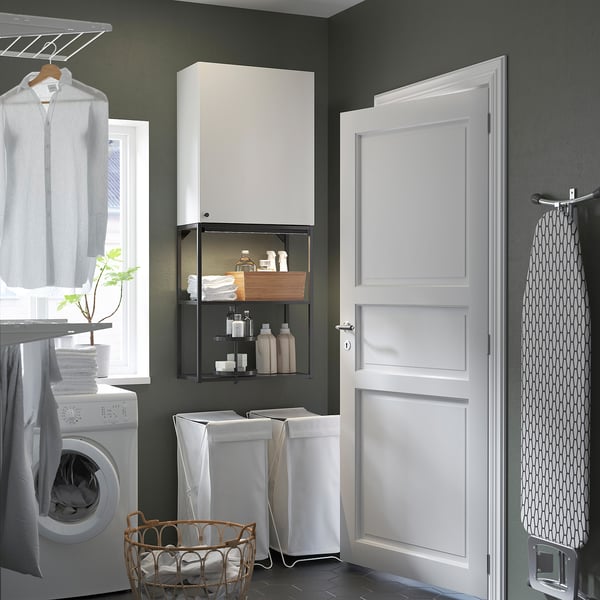 Modern laundry setup with ENHET cabinet, washer, and basket for supplies.