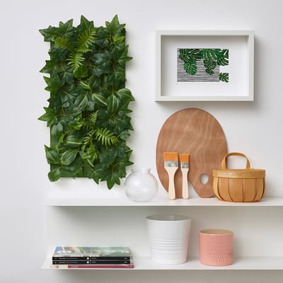 Green wall decor with FEJKA plant panel and shelves.