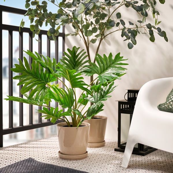 Balcony with FEJKA plants, table, chair, and lantern