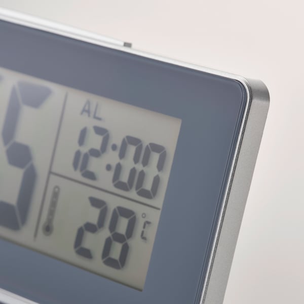 Close-up of digital clock showing time, alarm, and temperature. Clear display, high-quality design.