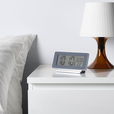 Bedside clock on bedside table, led display with time 17:17, temperature 22°c, and alarm set for 07:00.
