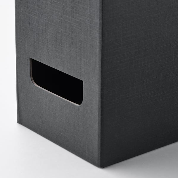 Black fabric-covered magazine file, standing upright. Cut-out handle for easy access. High-quality, modern design.