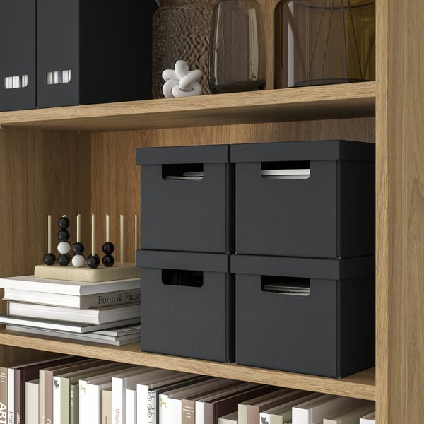 Wooden shelves with black storage boxes, decorative items, and books. Boxes ideal for small accessories, photos, and cords.