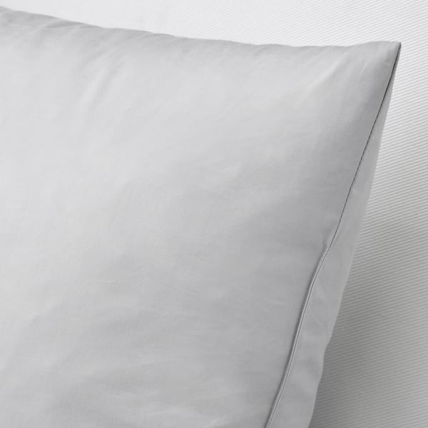 Close-up of a soft, down-filled cushion with cotton cover, showcasing its plush texture and quality.