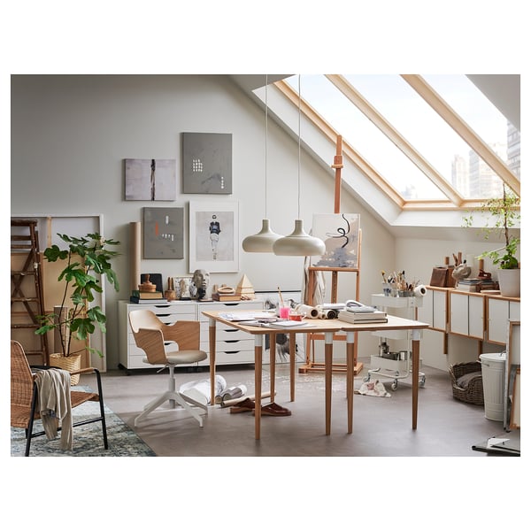 Artists studio with FJÄLLBERGET chair, table, easel, supplies, skylight, plant.