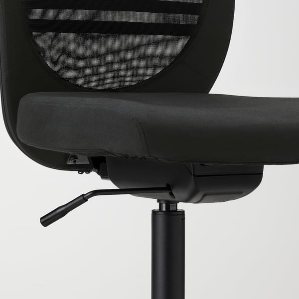 Black office chair, height adjustable, mesh back, tilt lock mechanism visible.