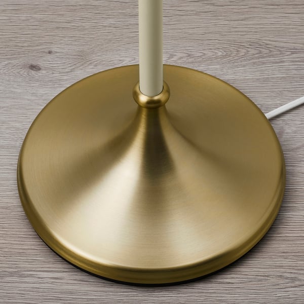Golden lamp base on wooden surface, achievable and stylish design.