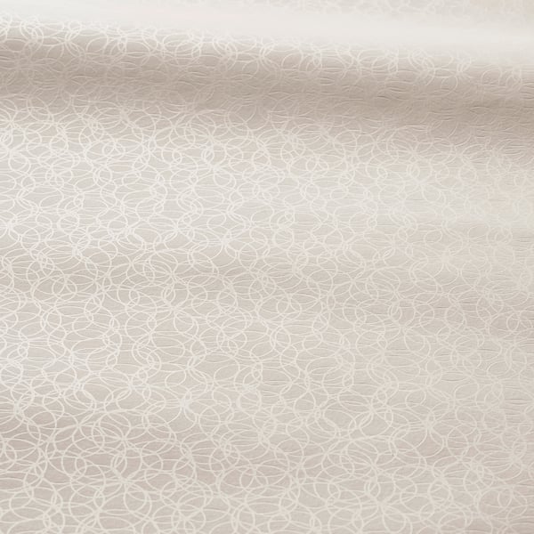 Soft, beige roller blind with subtle circular pattern, smooth texture, blocks light.