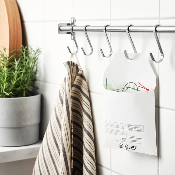 Towel, plant, and note on shower hooks.