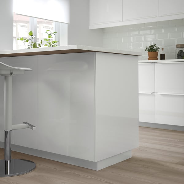 FÖRBÄTTRA white glossy counter; sleek, modern; fits well with wooden floors; surrounded by white cabinets.