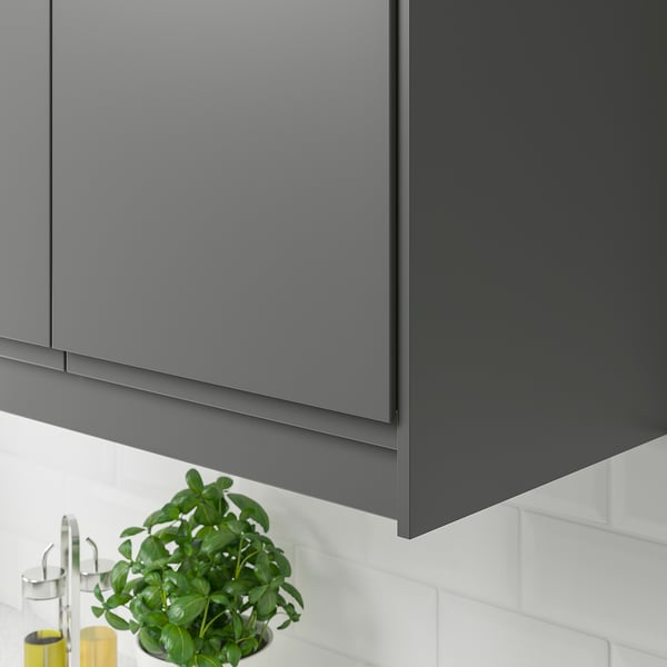 Dark grey kitchen cabinet edging conceals lighting and cords, with modern sleek design.