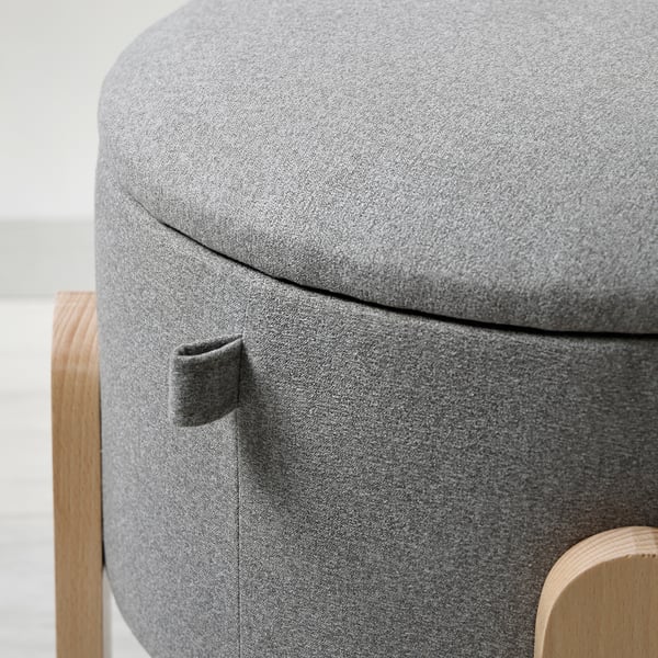 Circular upholstered stool with grey fabric, showing sturdy wooden handles and quality stitching.