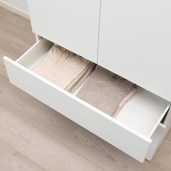 White cabinet drawer slightly open, revealing neatly folded clothes inside. Part of a platsa system for organised storage.