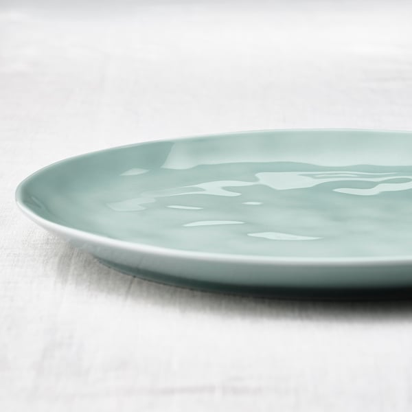 Smooth turquoise-grey dish with irregular, glossy finish, resting on a white surface.