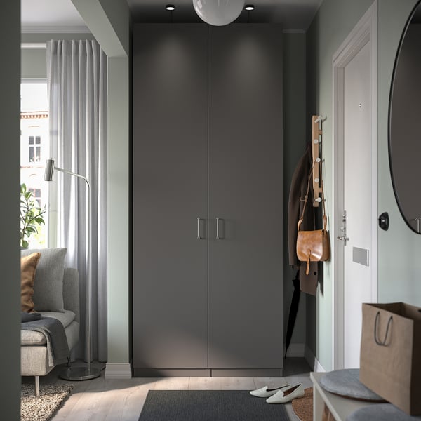 Dark grey modern entrance with tall storage cabinet, hanging coats, and plants.