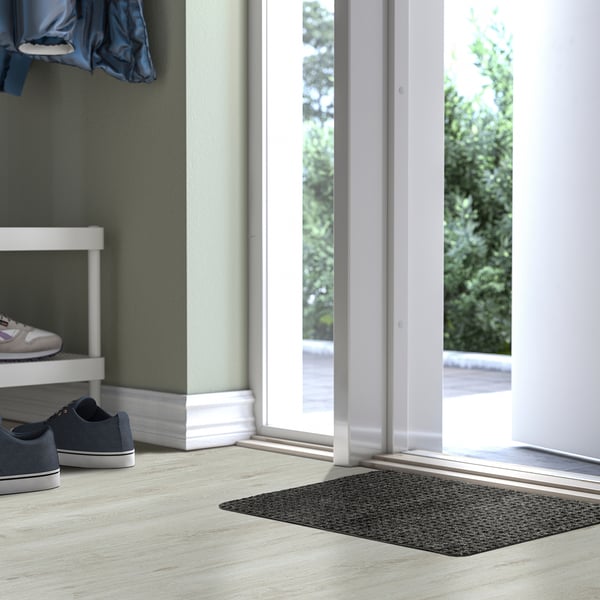 Grey FRIKTION doormat near glass door, checkered, polyester.