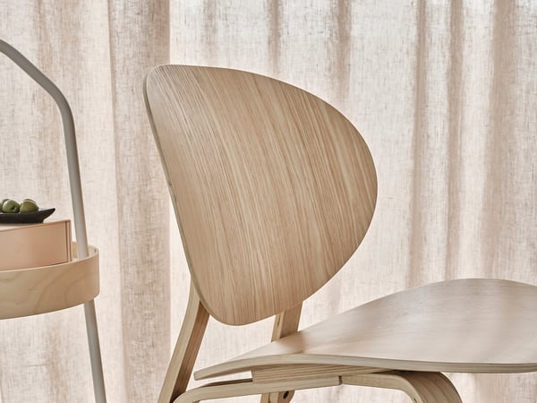 Wooden chair, light colour, curved back, minimalist design.