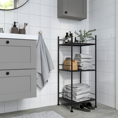 Modern bathroom with grey frosjon shelf, holding towels, next to a cabinet and mirror.