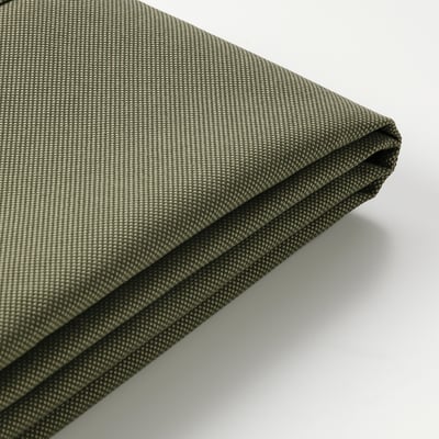 Close-up of durable, green, textured outdoor cushion with folded edge, showing quality fabric and stitching.