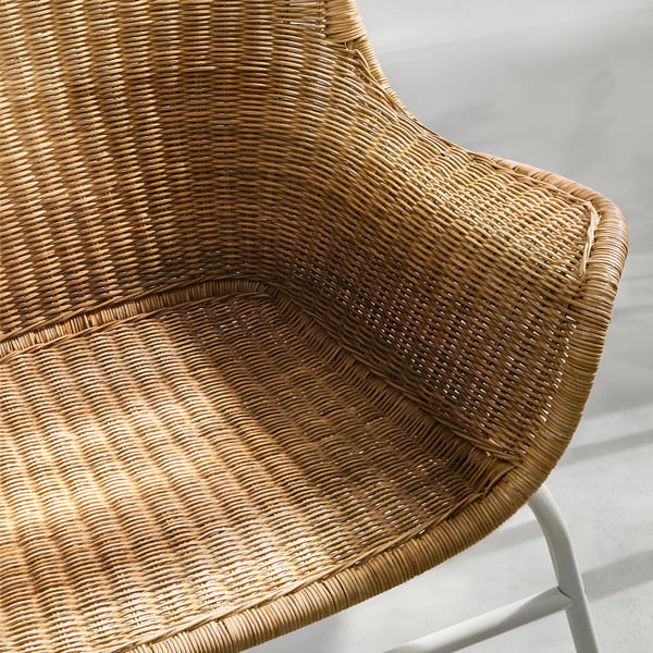 Close-up of wicker chair, intricate weave, curved back.