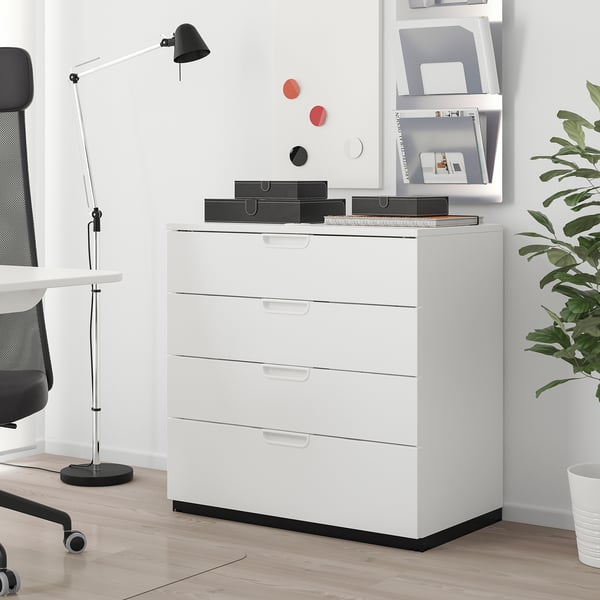 White GALANT 4-drawer filing cabinet in minimalist office, with lamp, boxes, and plant.