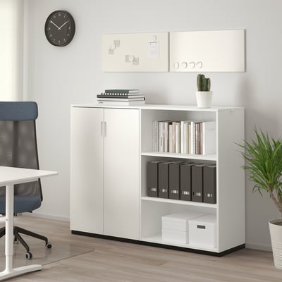 White GALANT office storage unit with open/closed shelves organising binders, books, and boxes, next to a blue chair and desk in a modern workspace.