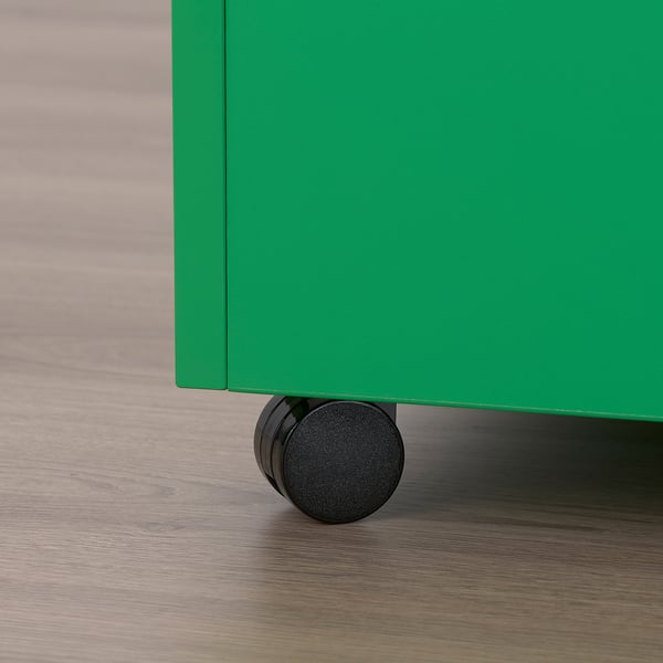 Close-up of green GARNANÄS table leg with black wheel on wooden floor.