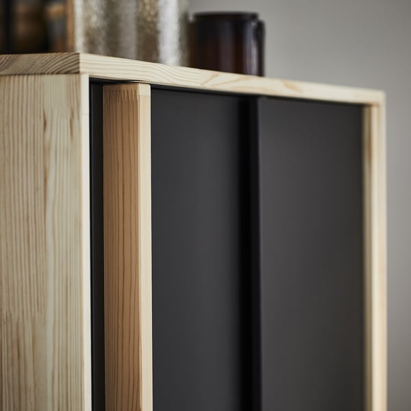 Wooden cabinet with black interior, featuring adjustable shelves. Light-colored, rectangular design.