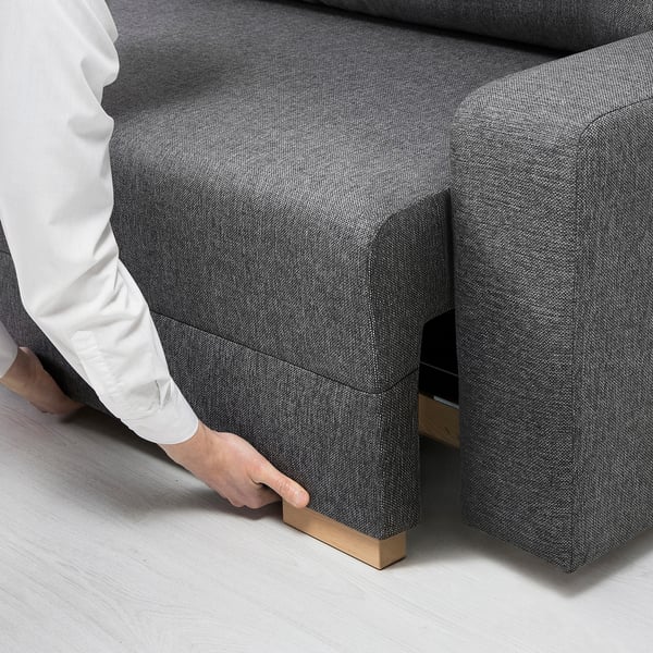 Person adjusting sofa-bed with storage underneath.